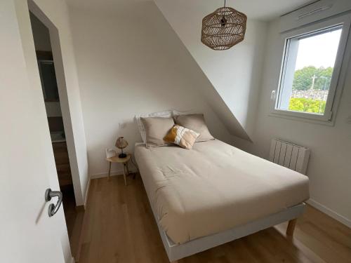 a small bedroom with a bed with a window at Appartement confortable à Bruz de 22 m² avec parking in Bruz