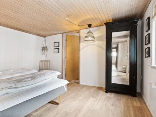 a bedroom with two beds and a mirror at Holiday Home Dana - 525m from the sea by Interhome in Tranekær