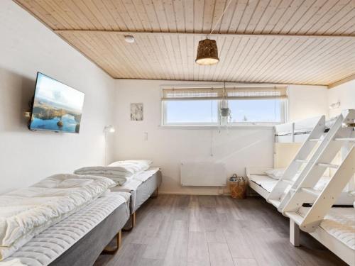 a room with four bunk beds and a tv at Holiday Home Dana - 525m from the sea by Interhome in Tranekær