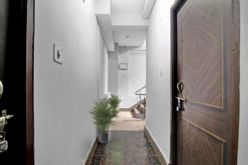 a hallway with a door and a potted plant at Hotel O Ganpati in Patna
