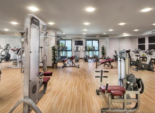 a gym with several treadmills and exercise machines at Bahi Ajman Palace Hotel in Ajman 