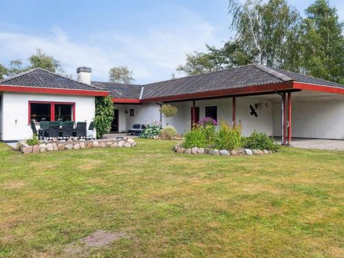 une maison blanche avec une pelouse devant dans l'établissement Holiday Home Hakon - 550m from the sea by Interhome, à Gedser