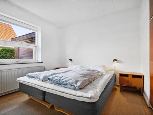 a bedroom with a bed and a window at Holiday Home Magh - 9-8km from the sea by Interhome in Tønder