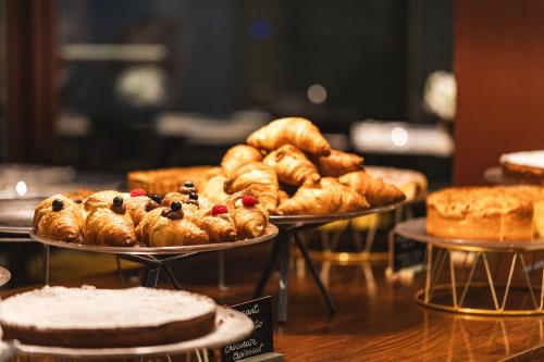 a table with three trays of pastries and pies at Casa D'Este - Hotel Ferrara in Ferrara