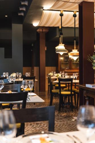 a dining room with tables and chairs and chandeliers at Casa D'Este - Hotel Ferrara in Ferrara