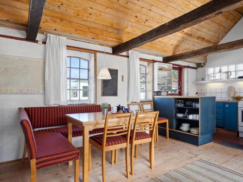 a kitchen and dining room with a wooden table and chairs at Holiday Home Bedri - 100m from the sea by Interhome in Læsø