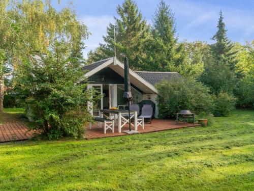 a cottage with a patio and a grill at Holiday Home Ninni - 3-2km from the sea by Interhome in Eskebjerg