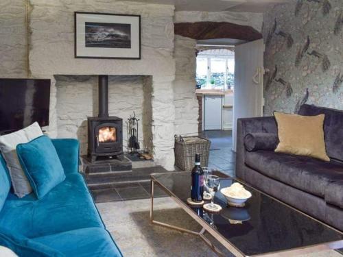 a living room with a couch and a fireplace at Cosy cottage with space and charm in Betws-y-Coed in Betws-y-coed