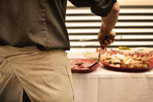 a chef standing in front of a table with a plate of food at Das Alte Rathaus in Egna