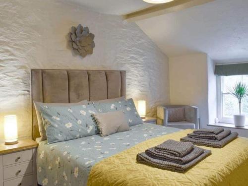 a bedroom with a bed with two towels on it at Cosy, characterful cottage in Betws-y-Coed in Betws-y-coed