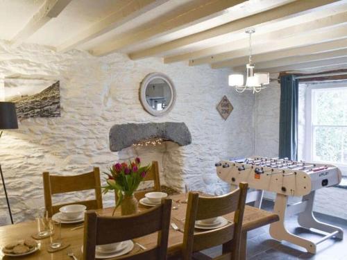 a dining room with a table and a stone wall at Cosy cottage with space and charm in Betws-y-Coed in Betws-y-coed