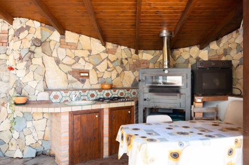 a kitchen with a stone wall with a stove at Bed And Breakfast Sciarammola in Patti