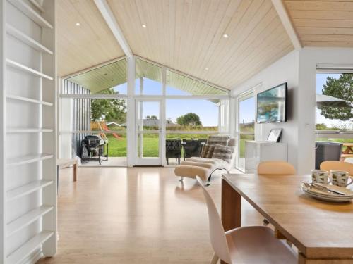 a living room with a wooden table and chairs at Holiday Home Thjodulf - 300m from the sea by Interhome in Knebel