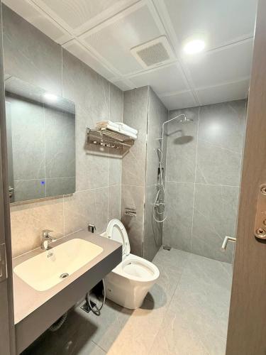 a bathroom with a toilet and a sink and a shower at Trường An Hotel in Cao Bằng