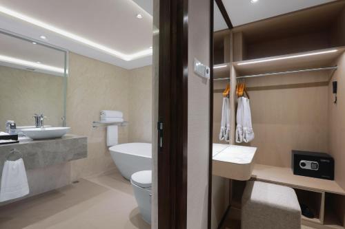 a bathroom with a toilet and a sink at The Alts Hotel in Palembang