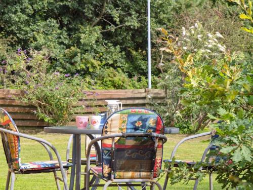 a table with two chairs and two cups on it at Holiday Home Aslak - 600m from the sea by Interhome in Glesborg