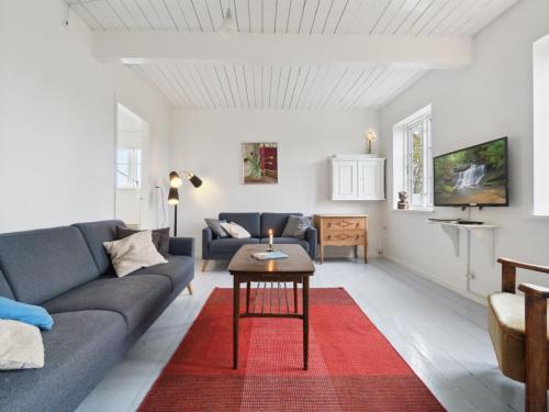a living room with a couch and a table at Holiday Home Torbjörn - 2-5km from the sea by Interhome in Gudhjem