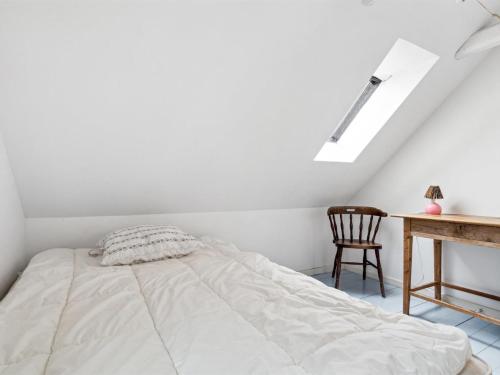 a white bedroom with a bed and a desk at Holiday Home Torbjörn - 2-5km from the sea by Interhome in Gudhjem