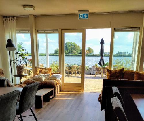 a living room with a view of the water at HotelPension van Ewijcksluis in Anna Paulowna