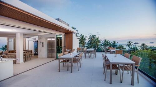 a restaurant with tables and chairs on a balcony at Royal Villa Fulidhoo in Fulidu