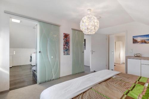 a bedroom with a large bed and a chandelier at Ferienwohnung Rosengarten in Mössingen