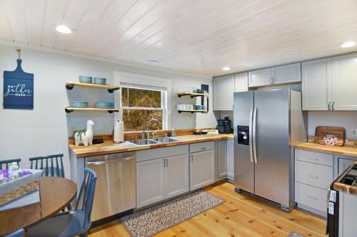 a kitchen with a stainless steel refrigerator and a table at 3 minutes to downtown, Hot Tub, Loft, Minutes to wineries in Ellijay