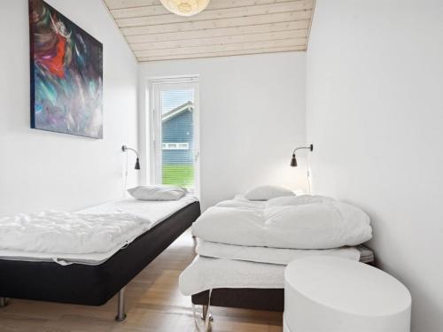 two beds in a white room with a window at Holiday Home Pascal - 600m from the sea by Interhome in Augustenborg