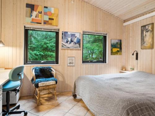 a bedroom with a bed and a desk and two windows at Holiday Home Aiko - 375m from the sea by Interhome in Store Fuglede