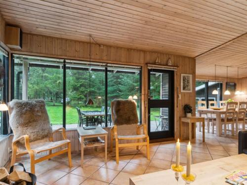 a living room with glass doors and a table and chairs at Holiday Home Aiko - 375m from the sea by Interhome in Store Fuglede