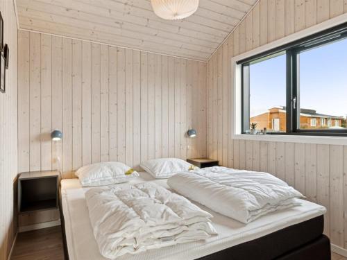 a large bed in a room with a window at Holiday Home Brothir - 500m from the sea by Interhome in Odder