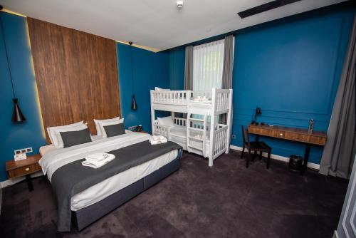 a bedroom with a bed and a desk and a crib at Hotel Twenties Tbilisi - Stay & Dine in Tbilisi City