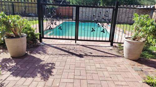 Una puerta negra con una piscina detrás. en Mooi Nooi, en Beaufort West