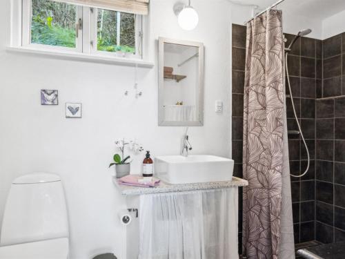 a bathroom with a sink and a shower curtain at Holiday Home Benni - 75m to the inlet by Interhome in Løgstør
