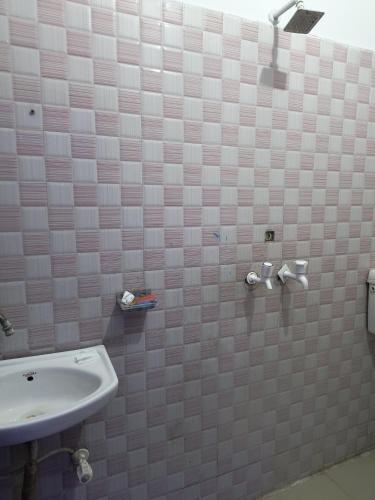 Un baño con lavabo y una pared de azulejos blancos. en Hotel Premium Rk madhav Residency - Near Prem mandir - Chaar Dham - Centrally Located- Bus And Car Parking Available, en Vrindāvan