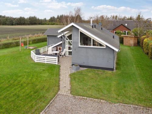 a small grey house on a grass field at Holiday Home Thrugels - 600m from the sea by Interhome in Hadsund