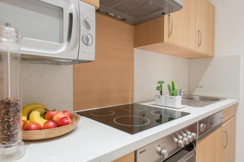 a kitchen with a bowl of fruit on the counter at Ferienwohnung Pension Tirol in Bichlbach