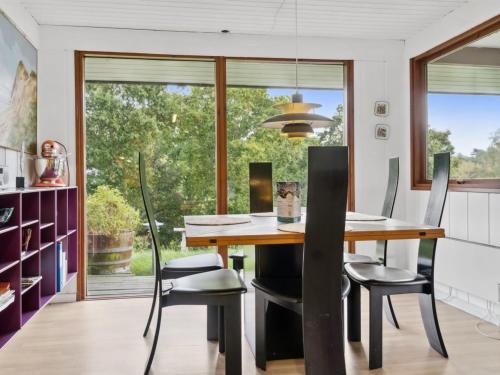 a dining room with a wooden table and chairs at Holiday Home Gundhild - 250m from the sea by Interhome in Ørby