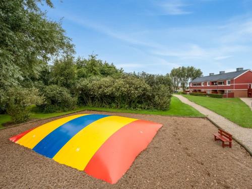 a colorful umbrella sitting on the ground next to a bench at Apartment Alvy - 100m to the inlet by Interhome in Lemvig