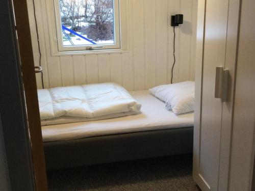 a bed in a room with a window at Holiday Home Sunaj by Interhome in Fårvang