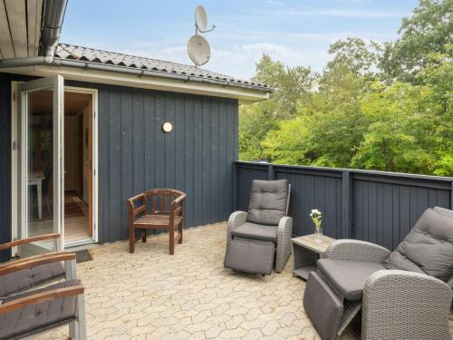a patio with chairs and tables and a building at Holiday Home Sunaj by Interhome in Fårvang