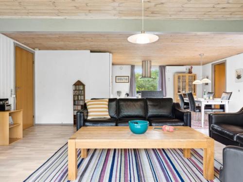 a living room with a couch and a table at Holiday Home Sunaj by Interhome in Fårvang