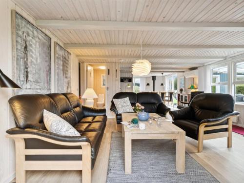 a living room with leather furniture and a table at Holiday Home Kjera - 450m from the sea by Interhome in Hadsund