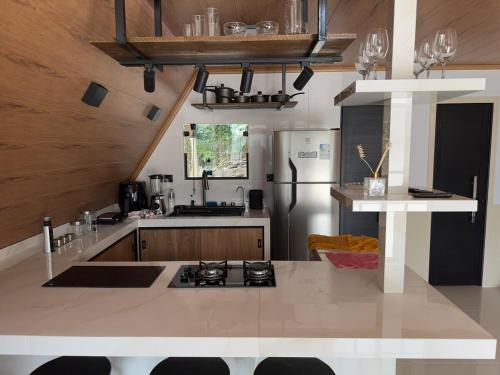 a kitchen with a stove and a refrigerator at Chalé Vale da Paz 500m da Praca in Palmeiras