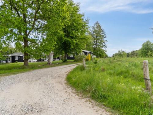 a dirt road next to a field with trees at Holiday Home Rami - 2km from the sea by Interhome in Tisvildeleje