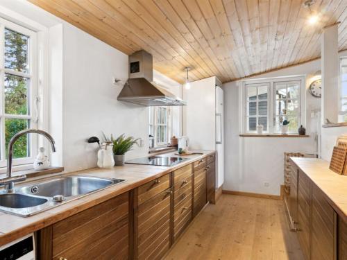 a kitchen with two sinks and a wooden ceiling at Holiday Home Rami - 2km from the sea by Interhome in Tisvildeleje