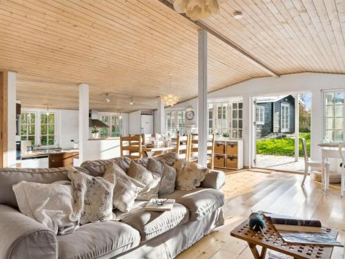 a living room with a couch and a table at Holiday Home Rami - 2km from the sea by Interhome in Tisvildeleje