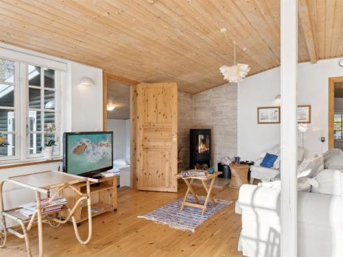 a living room with a white couch and a tv at Holiday Home Rami - 2km from the sea by Interhome in Tisvildeleje