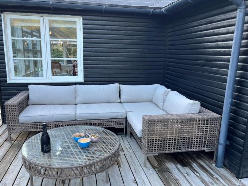 a patio with a couch and a table at Holiday Home Lucie - 50m from the sea by Interhome in Rønne
