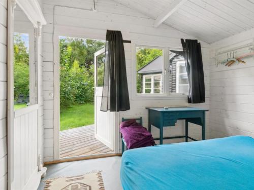 a bedroom with a blue bed and a desk at Holiday Home Lucie - 50m from the sea by Interhome in Rønne