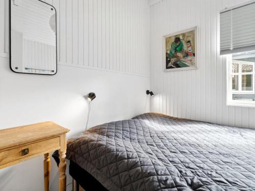 a bedroom with a bed and a table and a mirror at Holiday Home Lucie - 50m from the sea by Interhome in Rønne